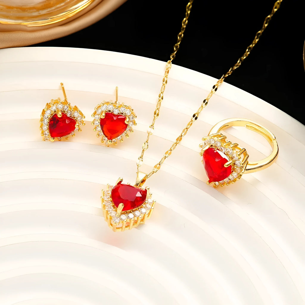 Gold-red titanium steel necklace with heart flower pendant, matching stud earrings, and ring on a grey background.