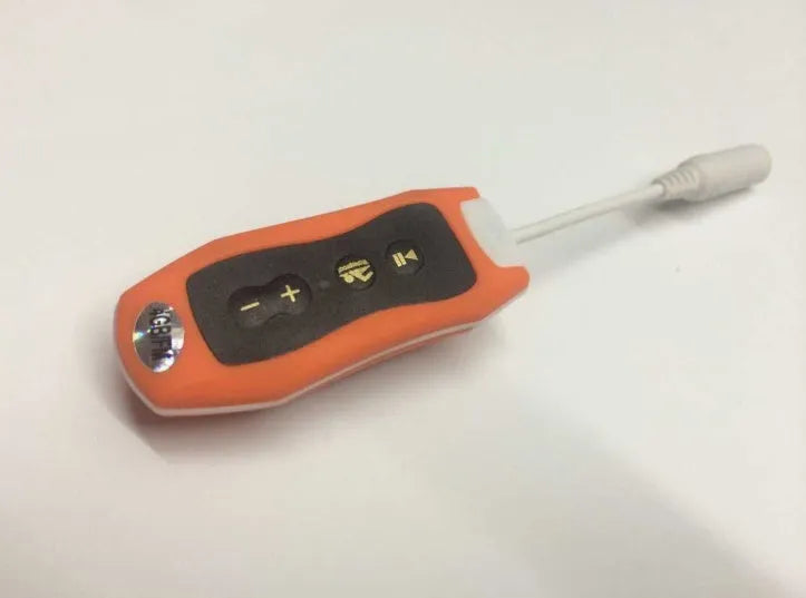 Compact black waterproof MP3 player earphone with USB cable, shown next to a ruler for scale.