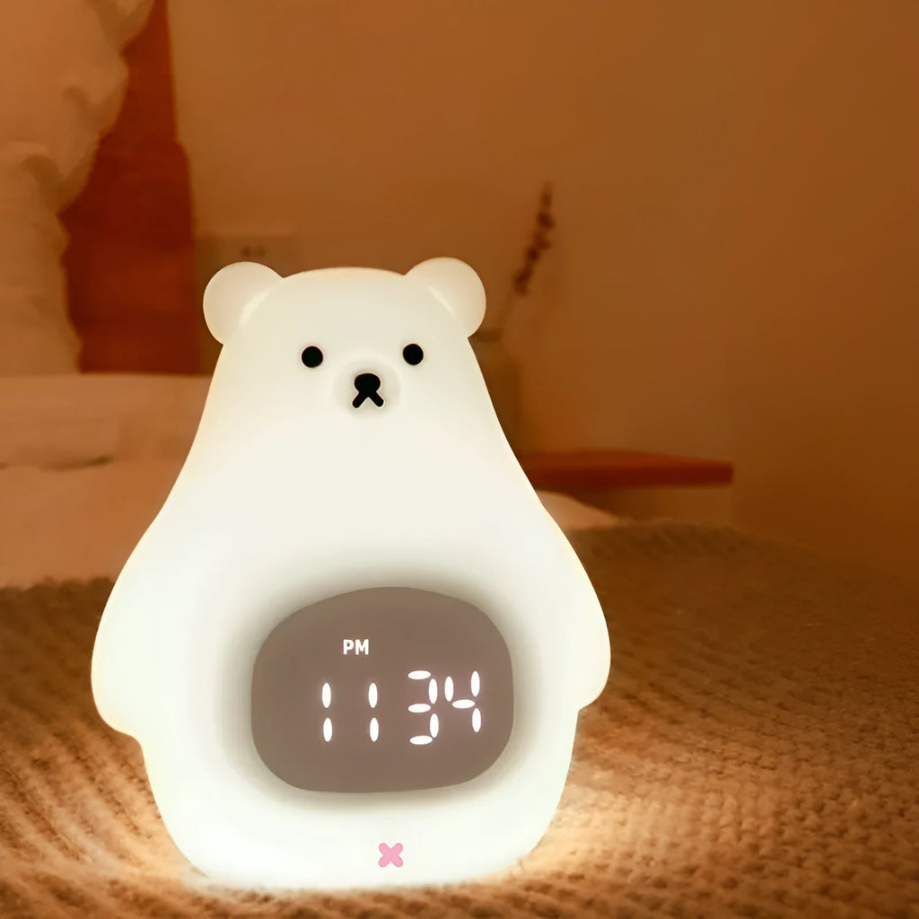 White silicone bear-shaped night light with remote control on a bedside table.
