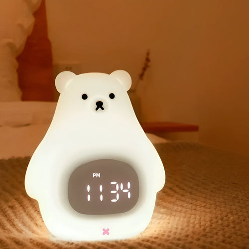 White silicone bear-shaped night light with remote control on a bedside table.