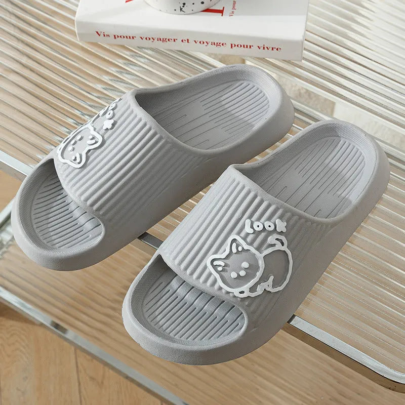 Women's pink EVA cat slippers with thick platform sole on a wooden floor.