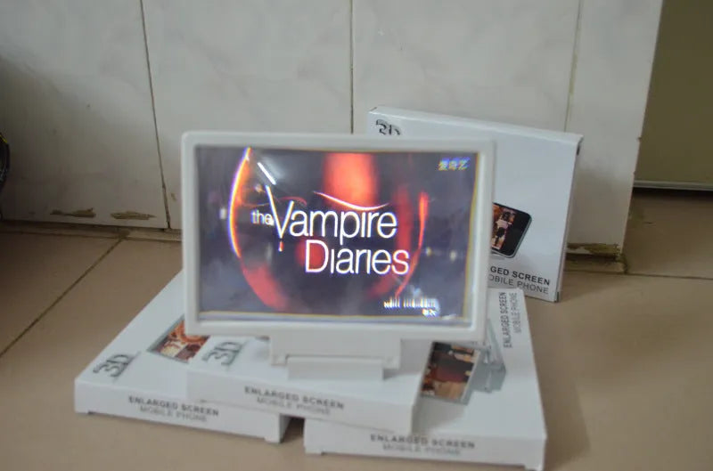 Black or white portable screen amplifier magnifier for mobile phones and laptops on a table.