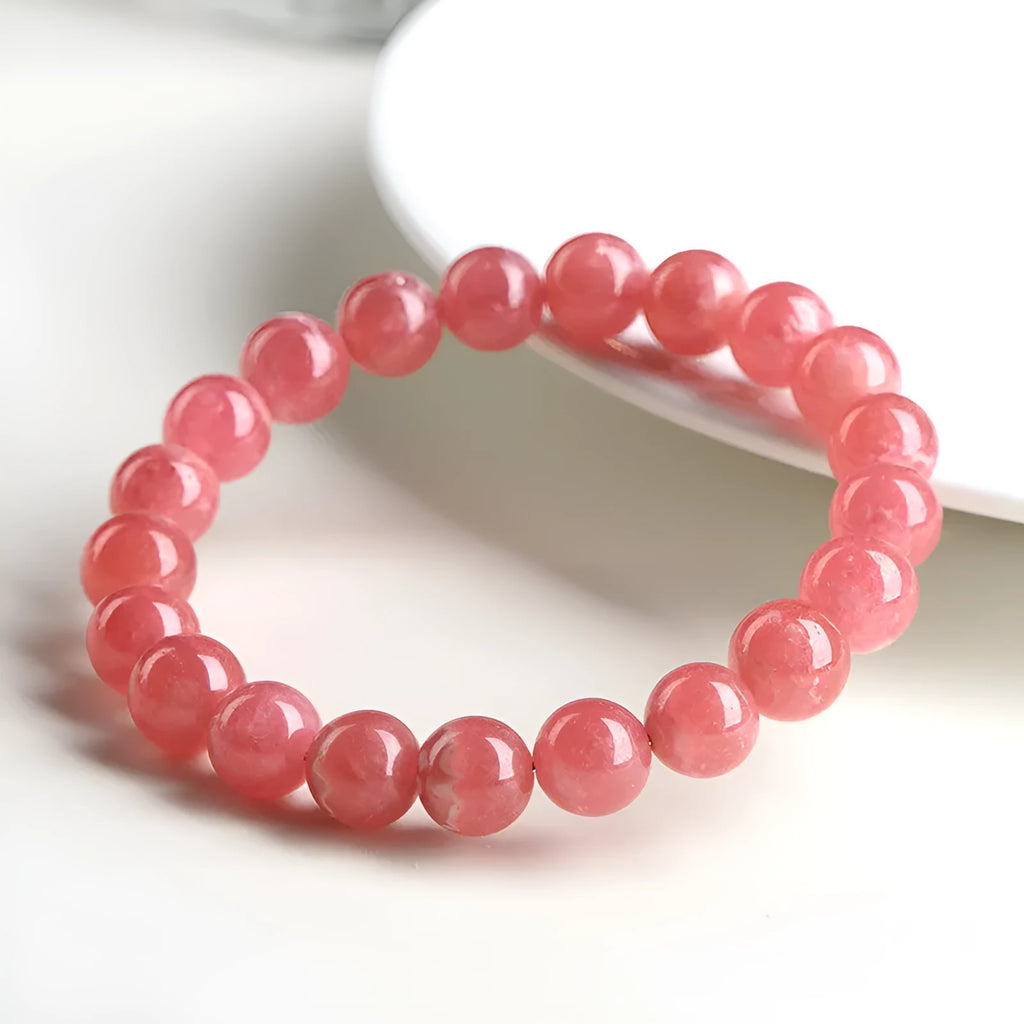 Women's geometric crystal bracelet with a longevity lock, shown in rhodochrosite colours.