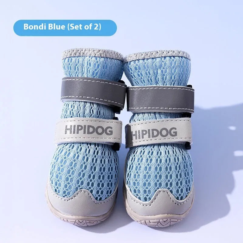 Pair of blue cartoon-style dog shoes with breathable PU uppers and anti-scald soles on a wooden surface.
