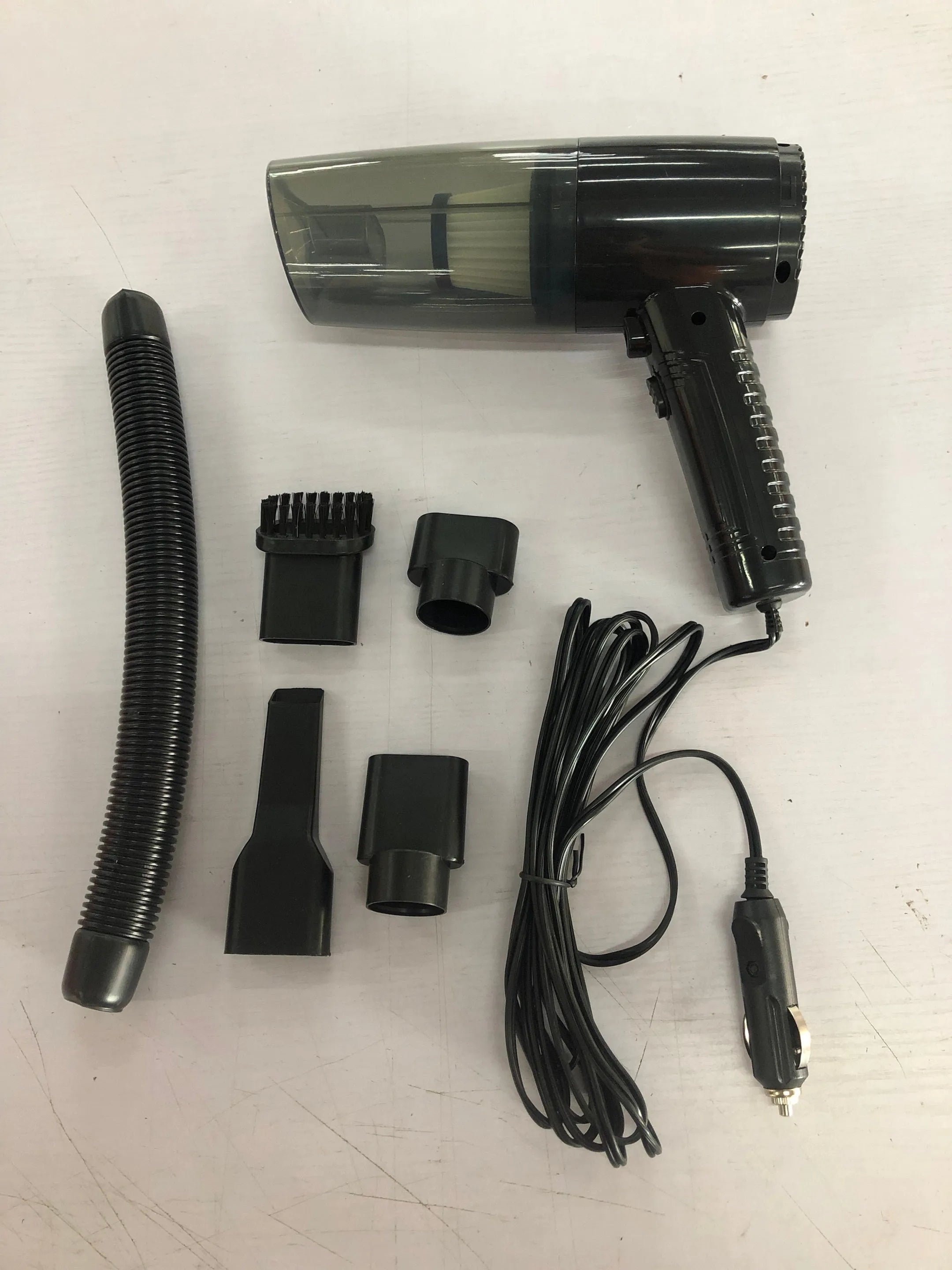 Powerful black and white mini car vacuum cleaner with suction attachments on a 5-metre cord.