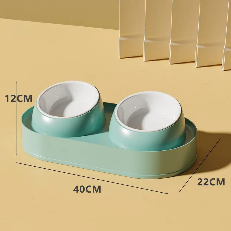 White elevated pet feeder with two tilted bowls on a wide base, for cats and small dogs.