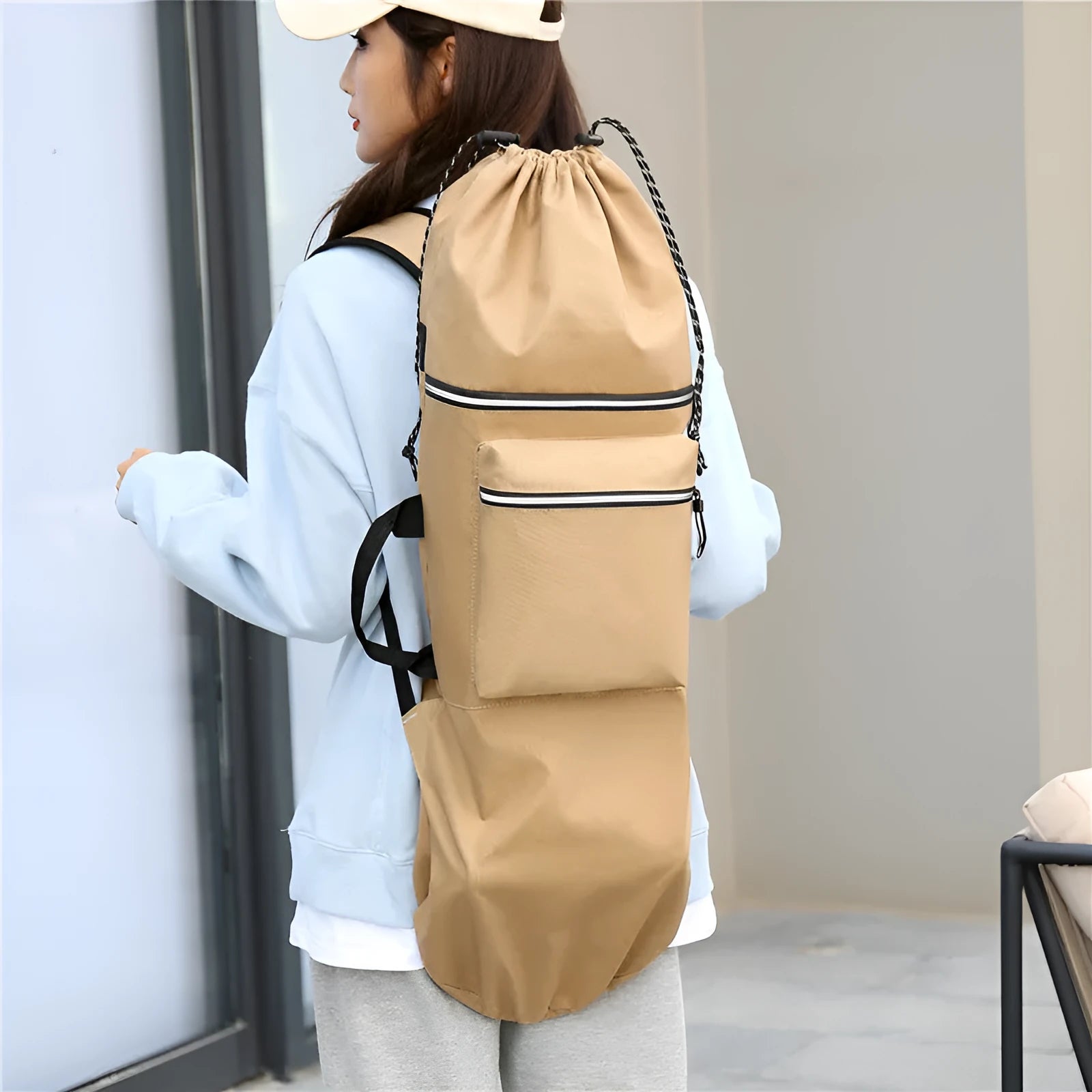 Black waterproof skateboard backpack with a longboard strapped to the side, showing padded shoulder straps.
