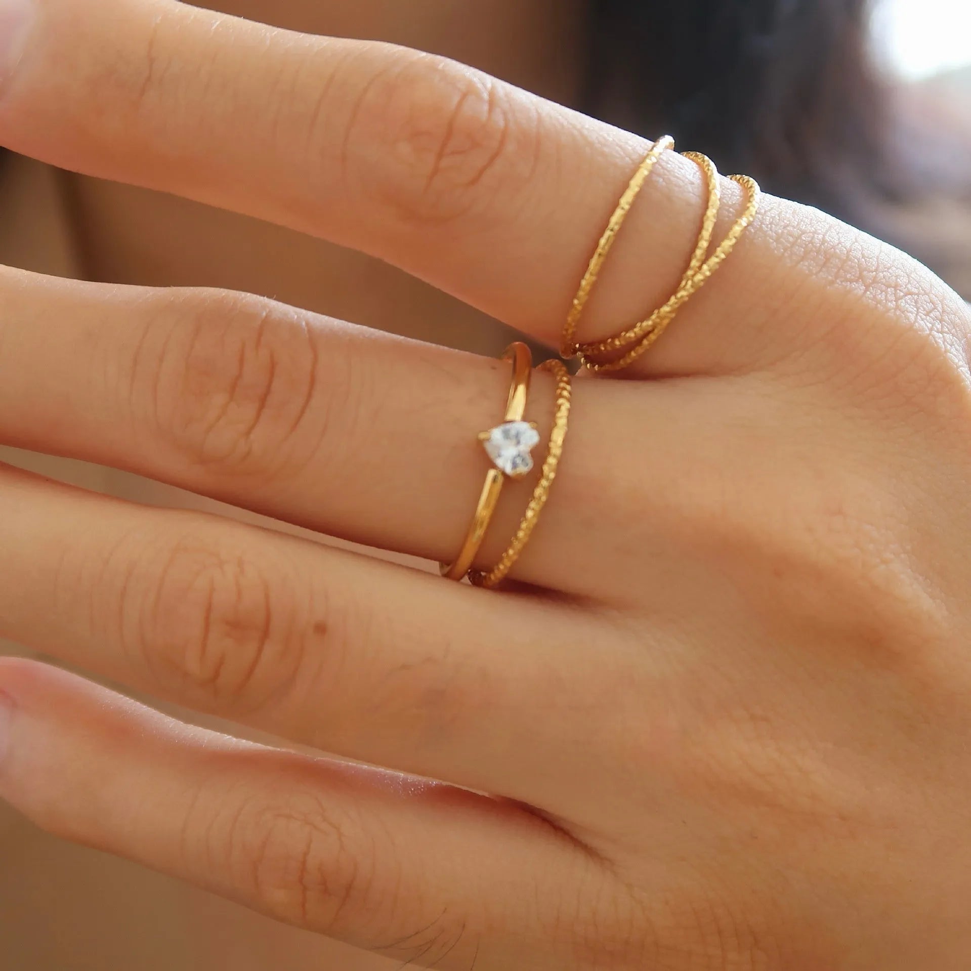 Golden love heart stainless steel ring showing heart shape design on female hand