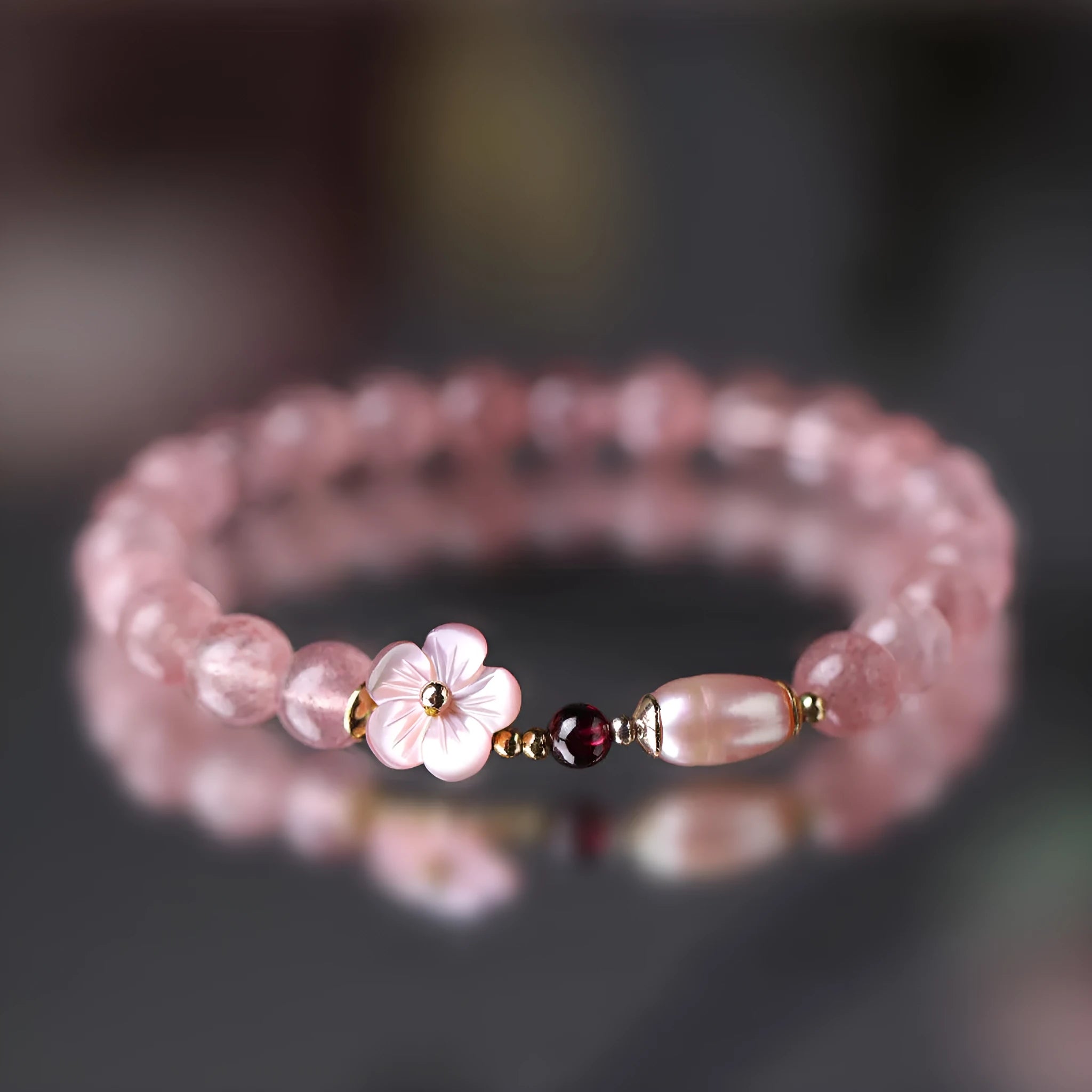 Women's strawberry quartz crystal flower bracelet showing peach blossom charm bead detail
