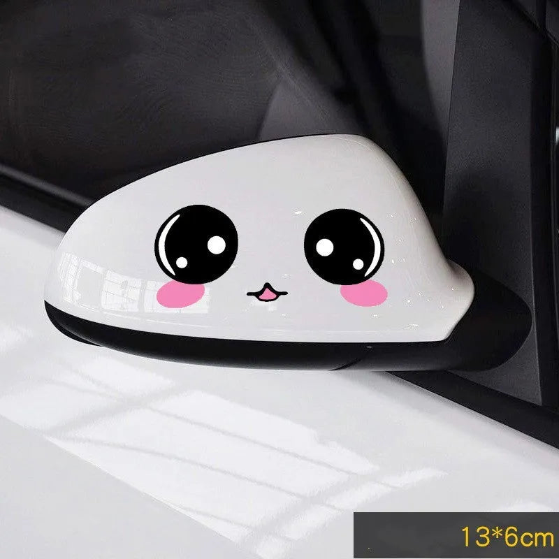 Pair of reflective cartoon car stickers with cute eyes on a car rearview mirror.