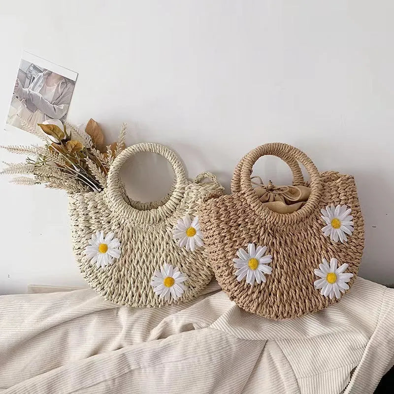 Light brown straw-weaved women's crossbody bag with daisy pattern, showing woven texture and crossbody strap