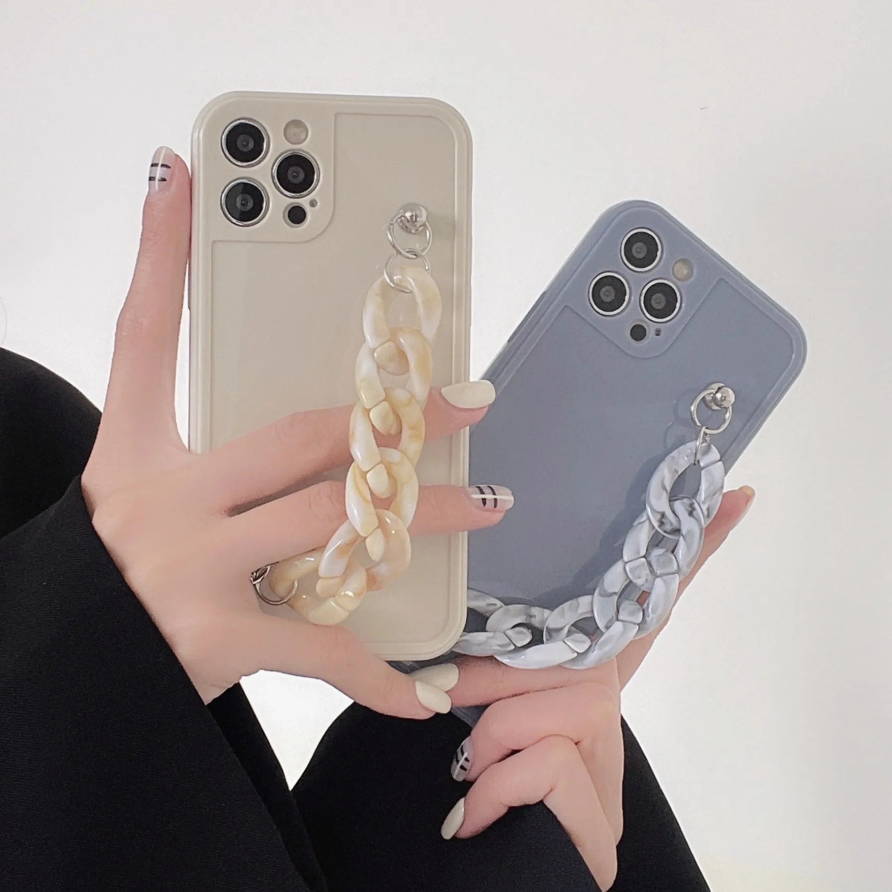 Marbled silicone phone case for iPhone with side lanyard hole in antique white, grey blue, and transparent coffee colours.