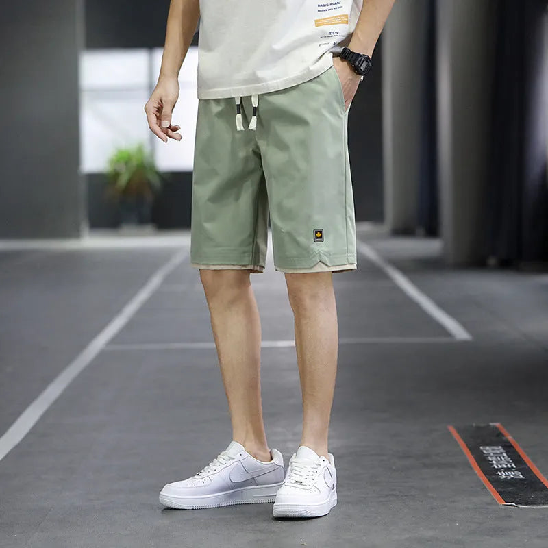 Korean style straight leg loose beach shorts in polyester, shown in green on a mannequin.