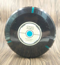 Black and white compact AC automatic sweeping robot vacuum cleaner on a wooden floor.