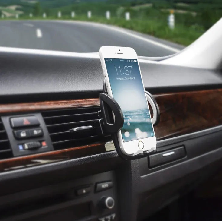 Black plastic car air vent phone holder attached to vehicle air conditioning outlet with mobile phone secured