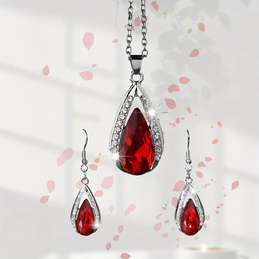 Black and red teardrop glass pendant necklace and matching earrings set on a jewellery display.