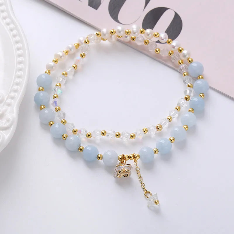 Close-up of a freshwater pearl and crystal double ring bracelet with a sliding bead closure.