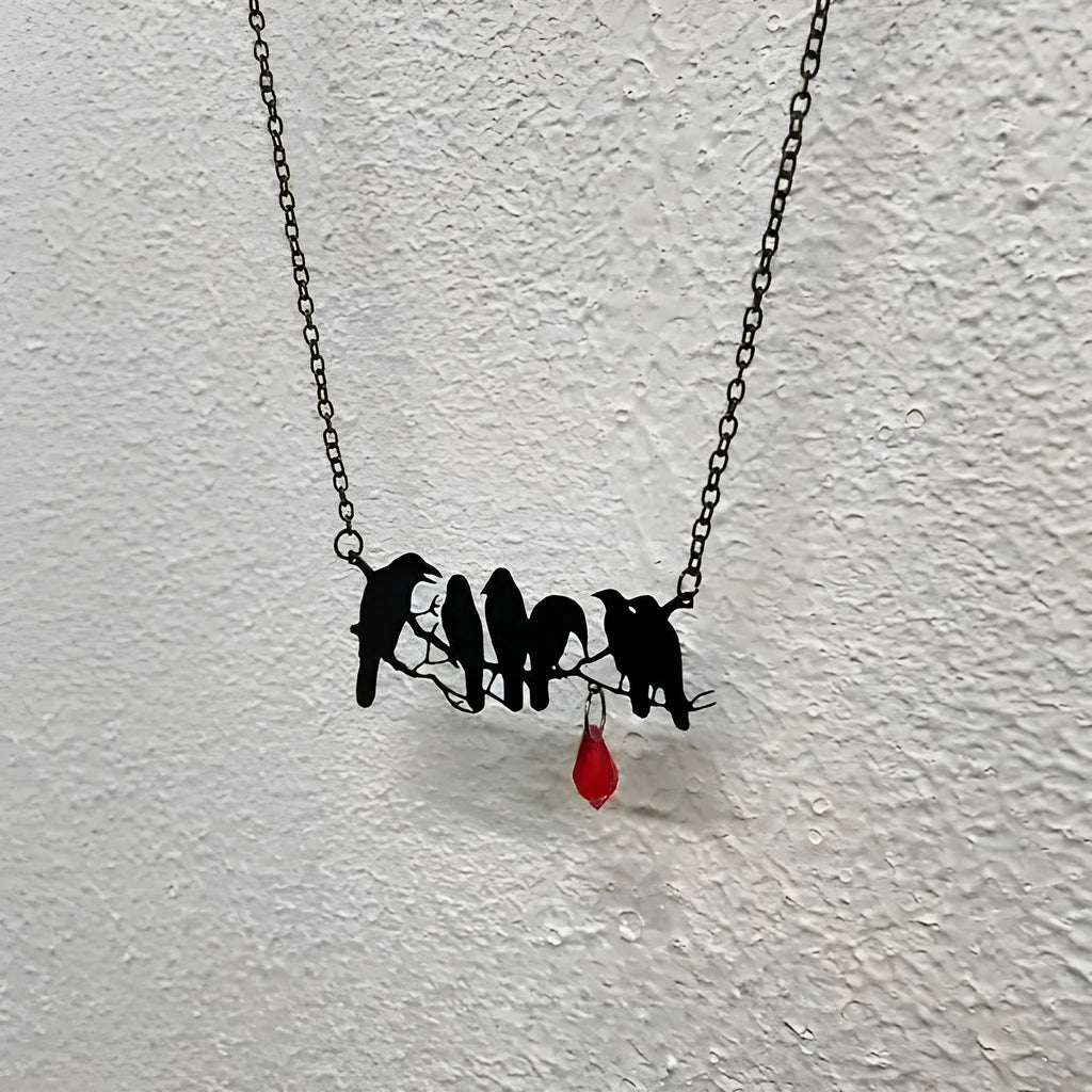 Black alloy crow pendant necklace on a cross chain for women, gothic bird motif jewellery.