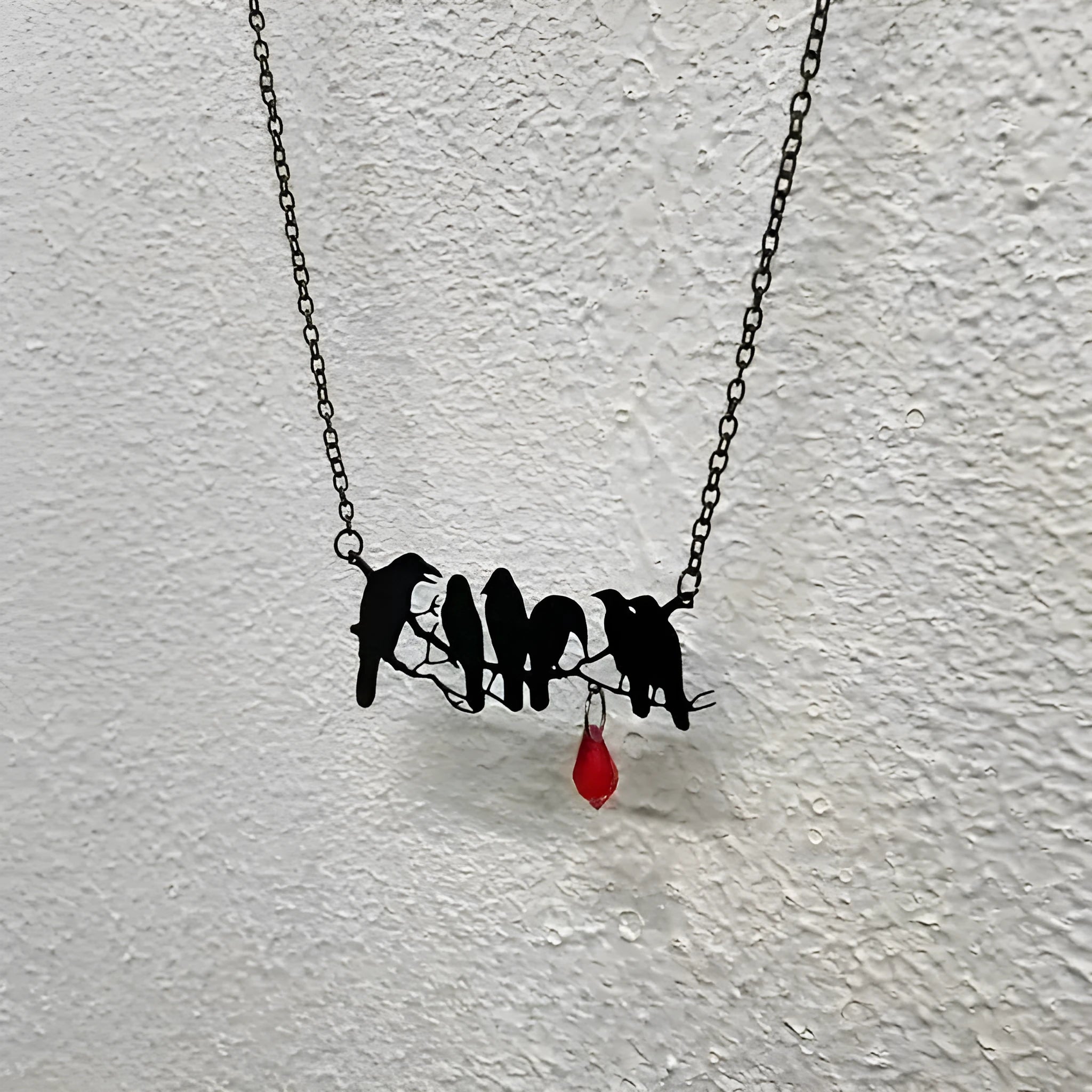 Black alloy crow pendant necklace on a cross chain for women, gothic bird motif jewellery.