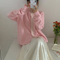 Retro style loose-fit viscose fibre cardigan in apricot colour, shown on a hanger.
