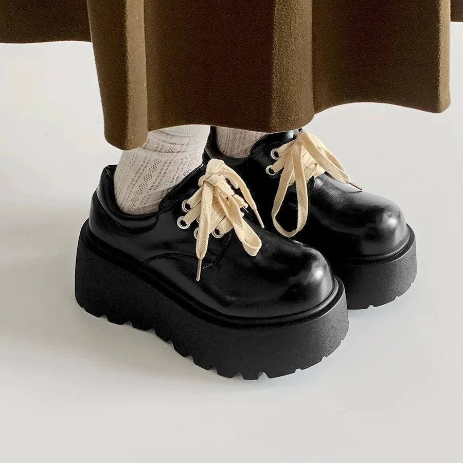 Matte black women's lace-up shoes with a chunky muffin heel and thick rubber sole