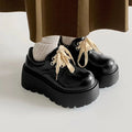 Matte black women's lace-up shoes with a chunky muffin heel and thick rubber sole