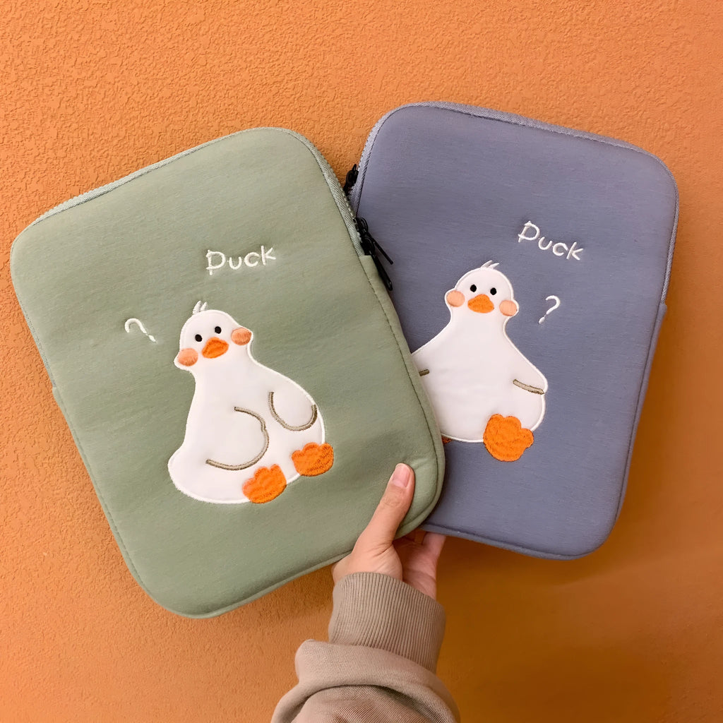 Blue cotton tablet case with embroidered cartoon duck design and a black zipper, shown open.