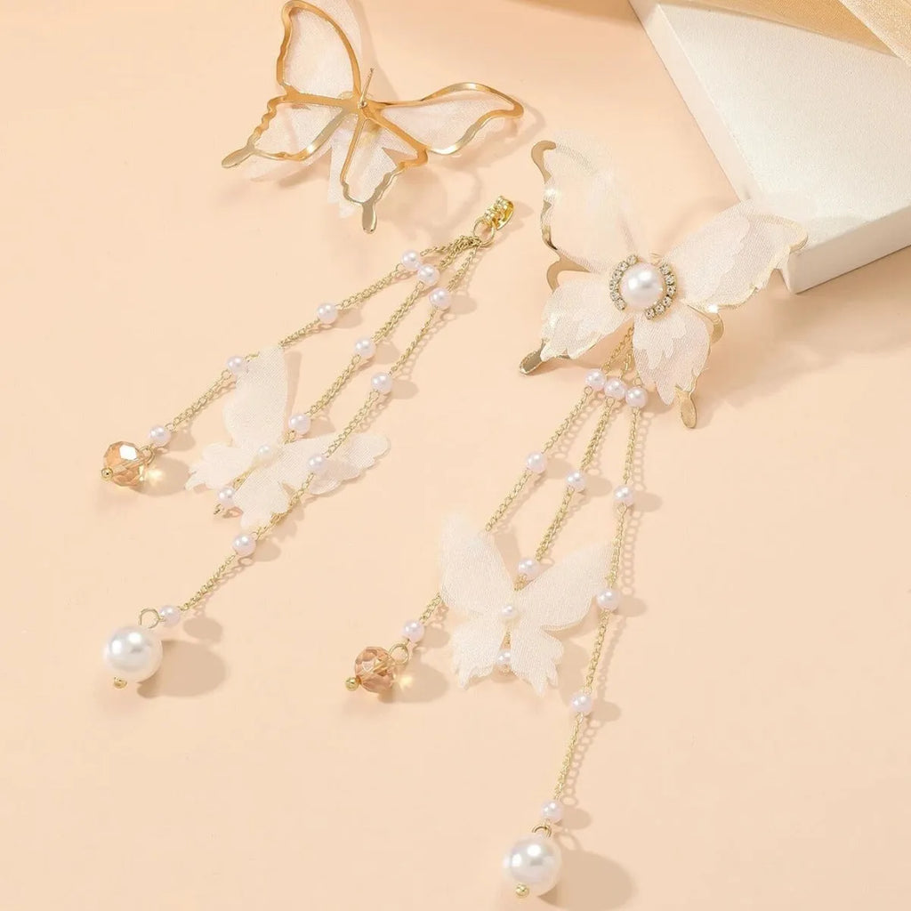 White butterfly shaped earrings with lace metalwork, a dangling tassel, pearl accents, and sparkling rhinestones.