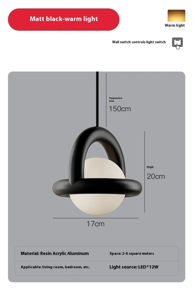 Matte black hanging line lamp with a long black cord suspended above a bedside table.
