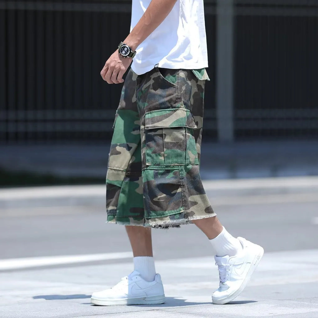 Man wearing loose, cropped camouflage shorts in a khaki colourway, showcasing the summer workwear style.