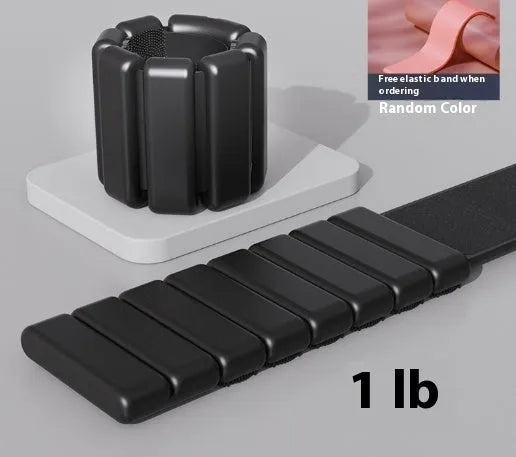 Close-up of a grey detachable weighted fitness bracelet with Velcro strap on a wrist.