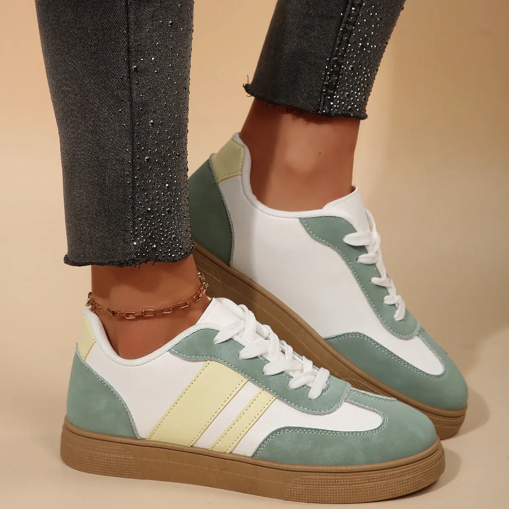 Green women's retro sports pumps with cross straps, leather stitching, and a round toe on a rubber sole.
