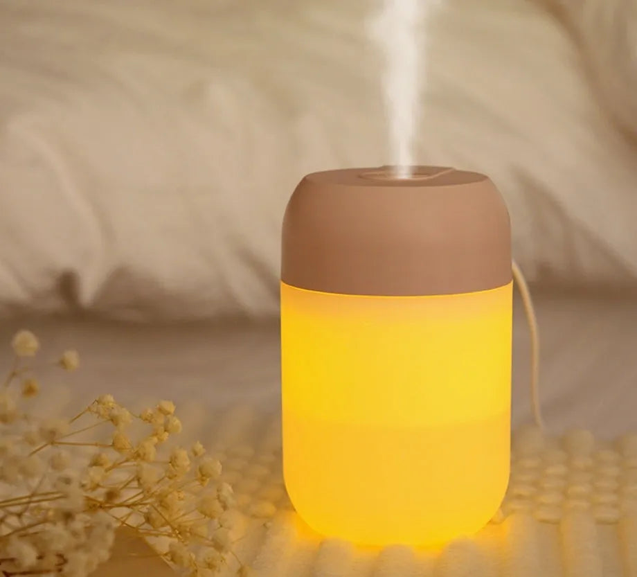 Small white cylindrical USB-powered humidifier with charging cable.