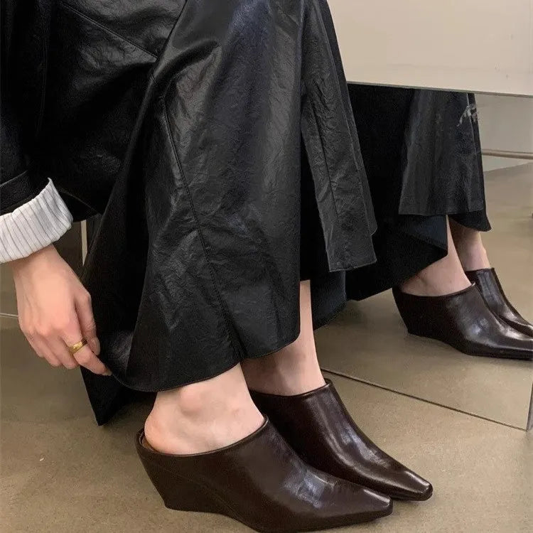 Women's black Wind Wedge closed toe half slippers with PU upper on a wooden floor.