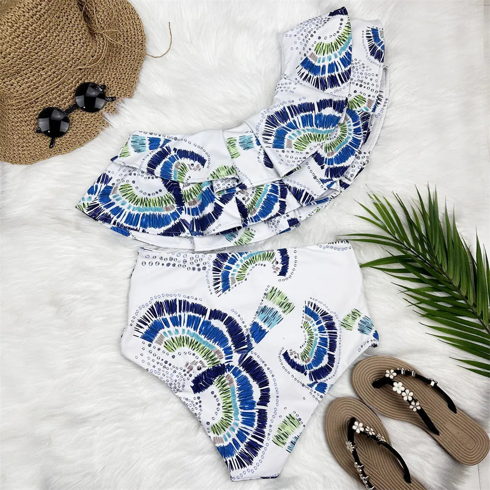 White one-shoulder women's swimsuit with a large layered lotus leaf skirt and split-leg design.