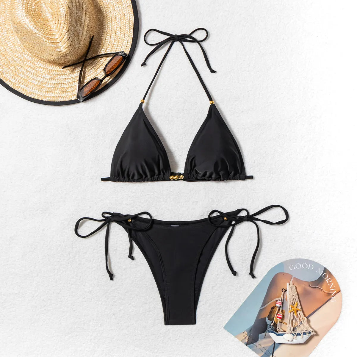 Black women's bikini swimsuit with split bottom and metal bead detail on ties.