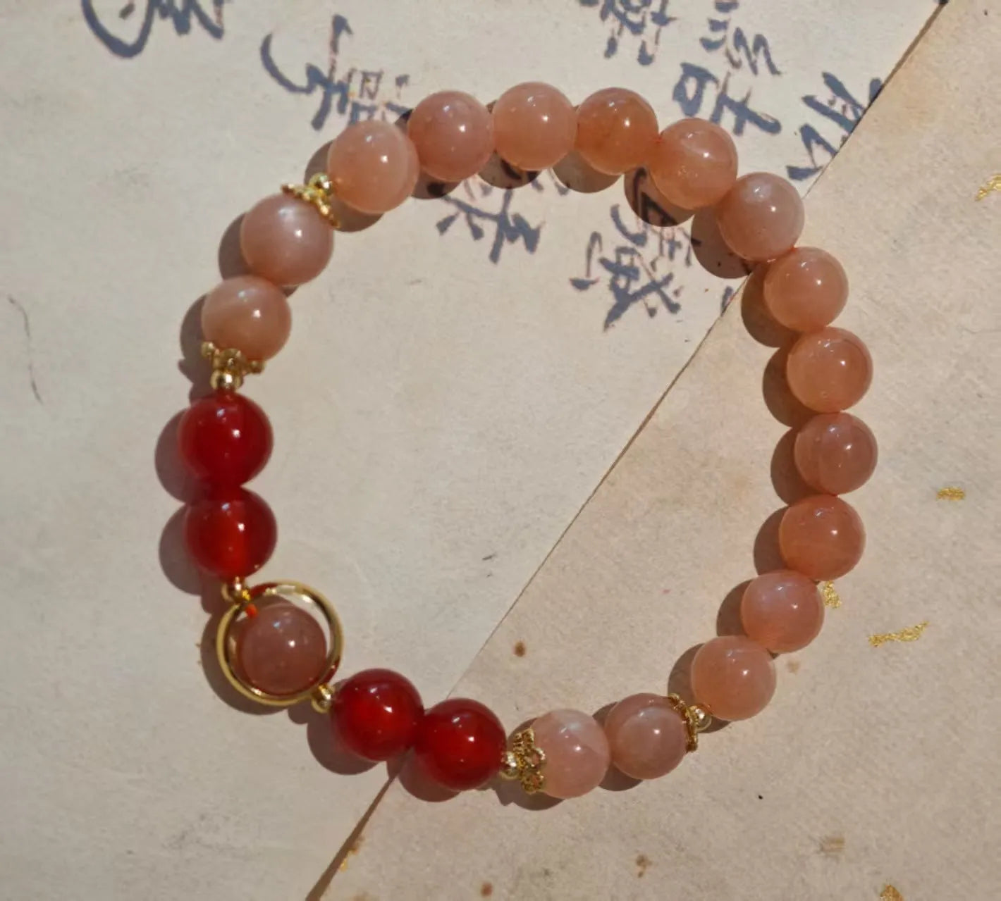 Handmade red agate and orange sunstone bracelet with star and cloud motifs