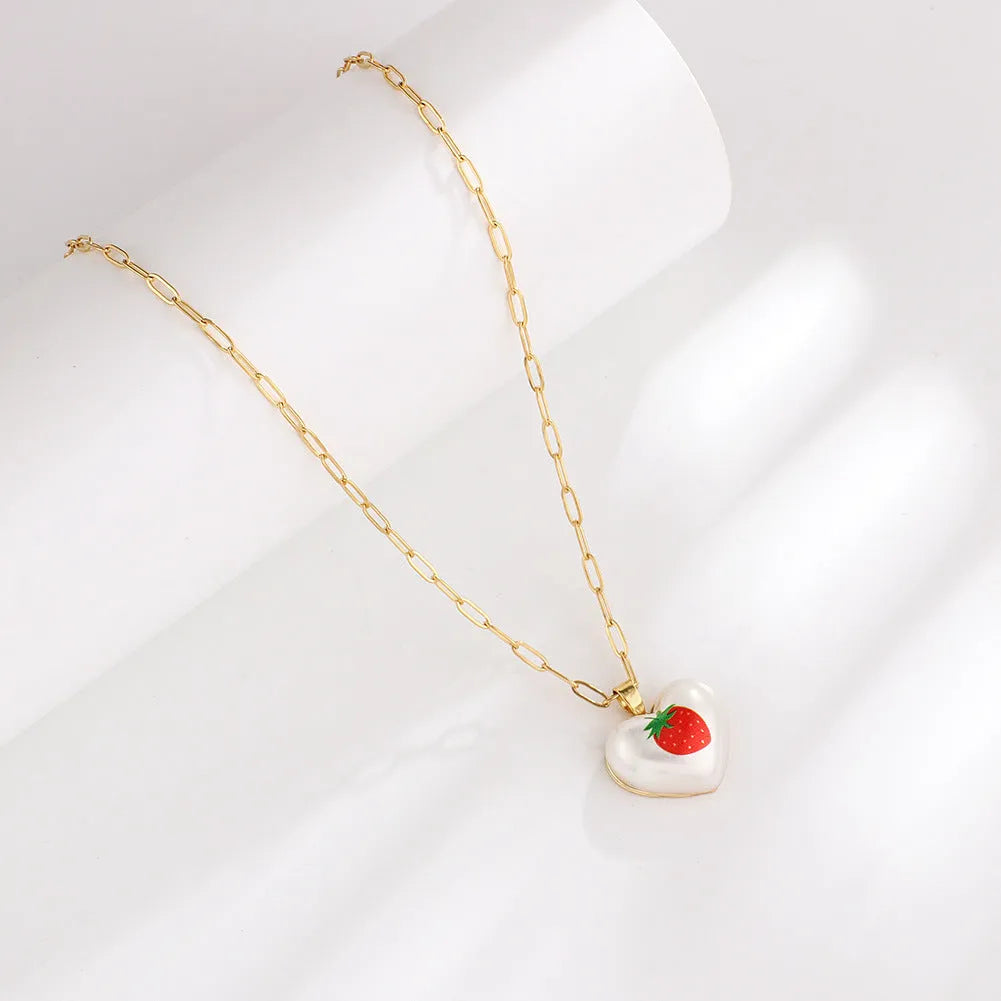Heart-shaped necklace with fruit pendant on geometric chain showing strawberry pineapple apple pear cherry options