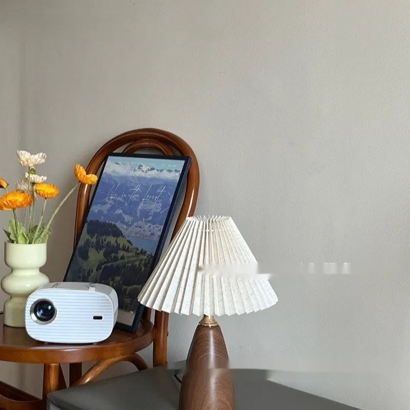 Nordic retro style ceramic table lamp with a tapered floral pleated shade and remote control on a wooden surface.
