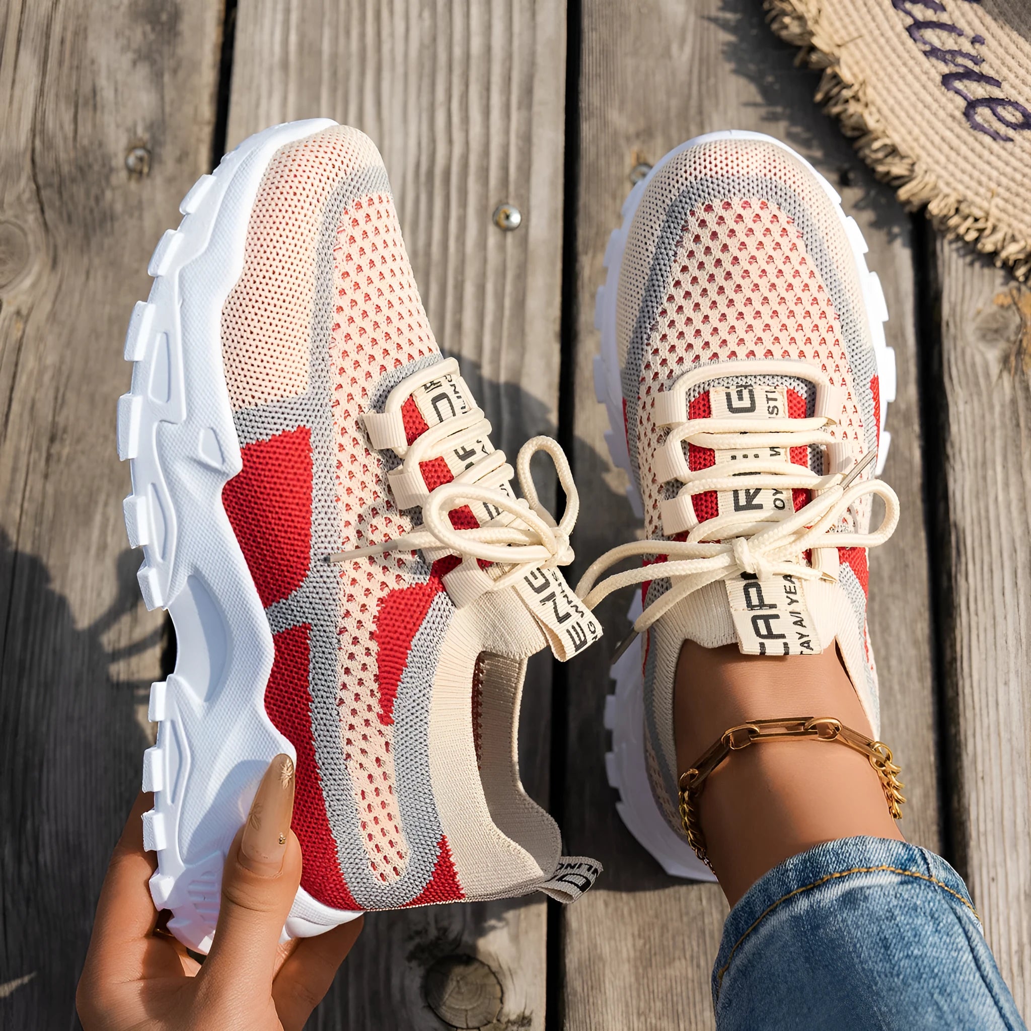Women's Flyknit mesh lace-up sneakers in grey and white with a low rubber sole.
