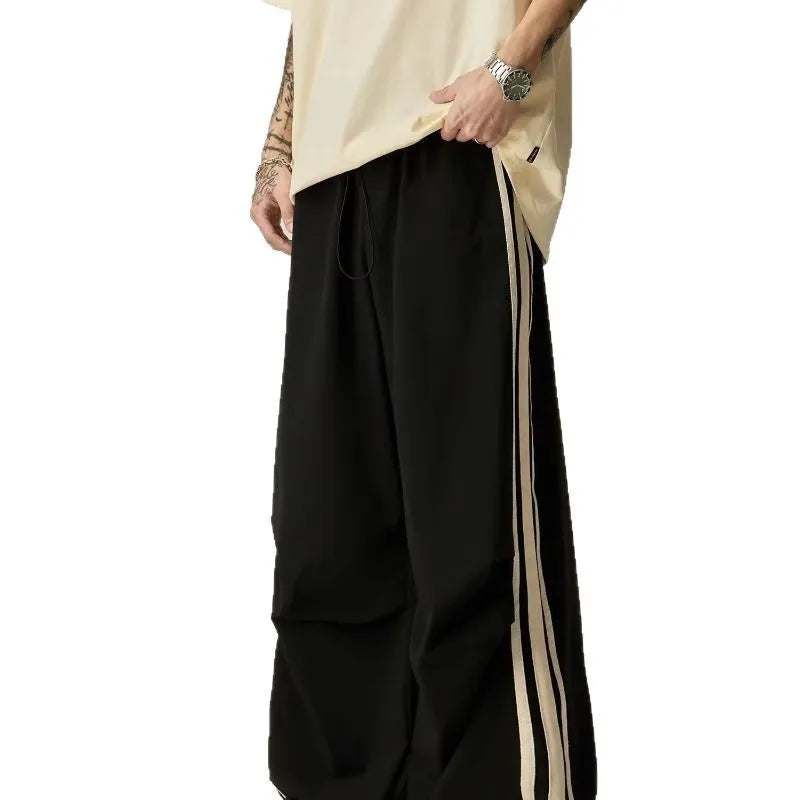 Black wide-leg straight-cut men's climbing trousers with a high waist on a hanger.
