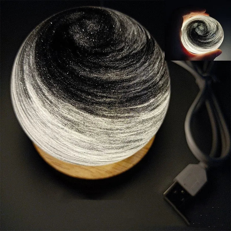 Modern planet-shaped USB night light with dimming on a desk.