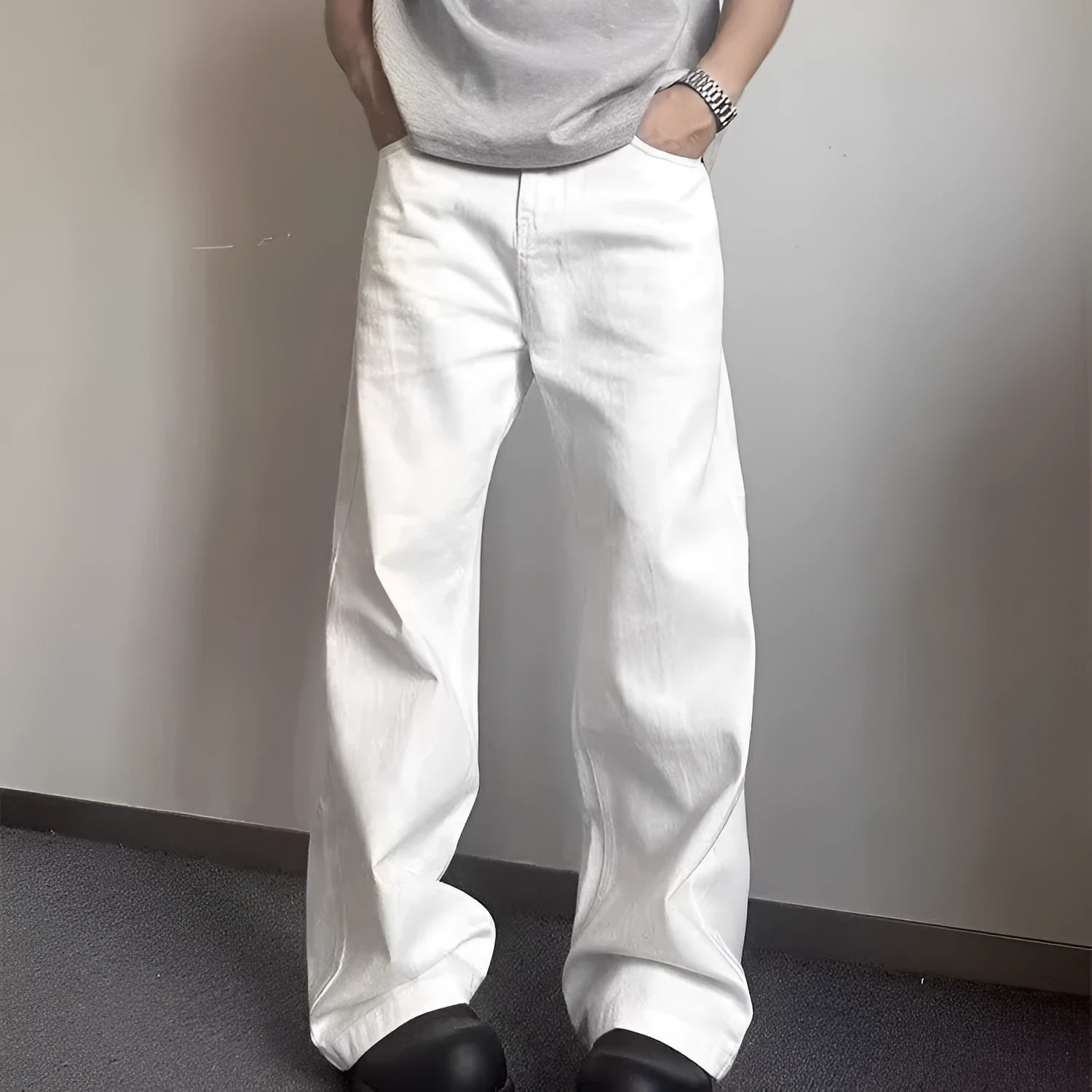 Man wearing white straight-leg cotton denim jeans with a wide leg opening.
