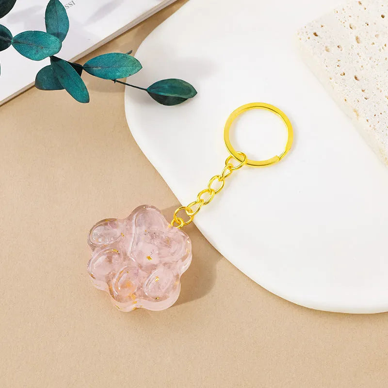 Hand-finished natural crystal cat's paw keychain pendant on a metal ring, showing detailed carving and polished stone surface.