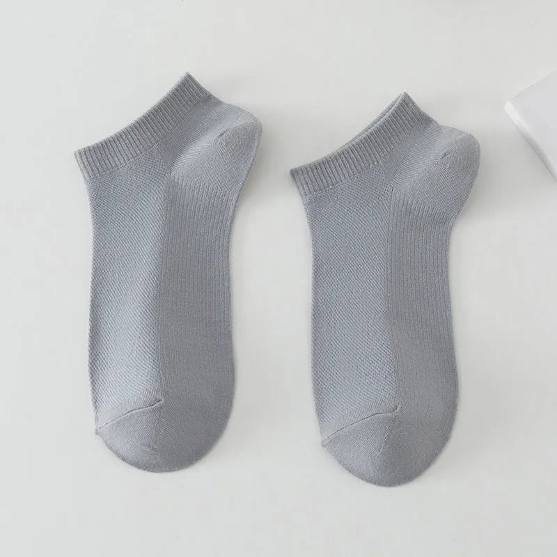 A pair of solid colour low-cut men's boat socks made from breathable polyester fabric.