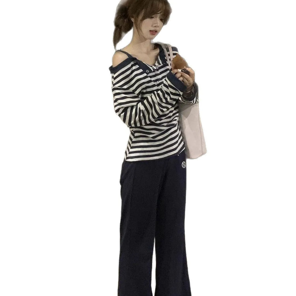 Dark blue women's oversized long-sleeve t-shirt with embroidery and stripe details on a hanger.