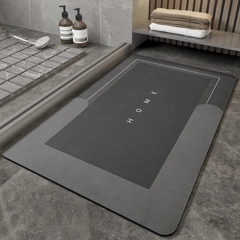 Machine-woven blended bathroom floor mat in blue, shown in an oval shape on a tiled floor.