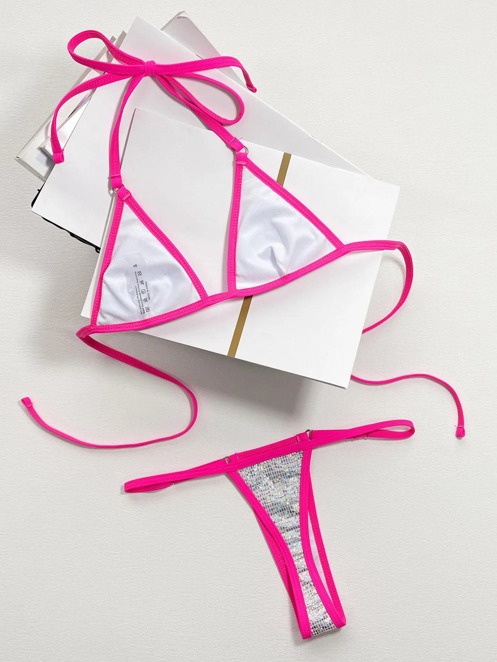 Silver one-piece women's swimsuit with a split triangle bag design on a mannequin.