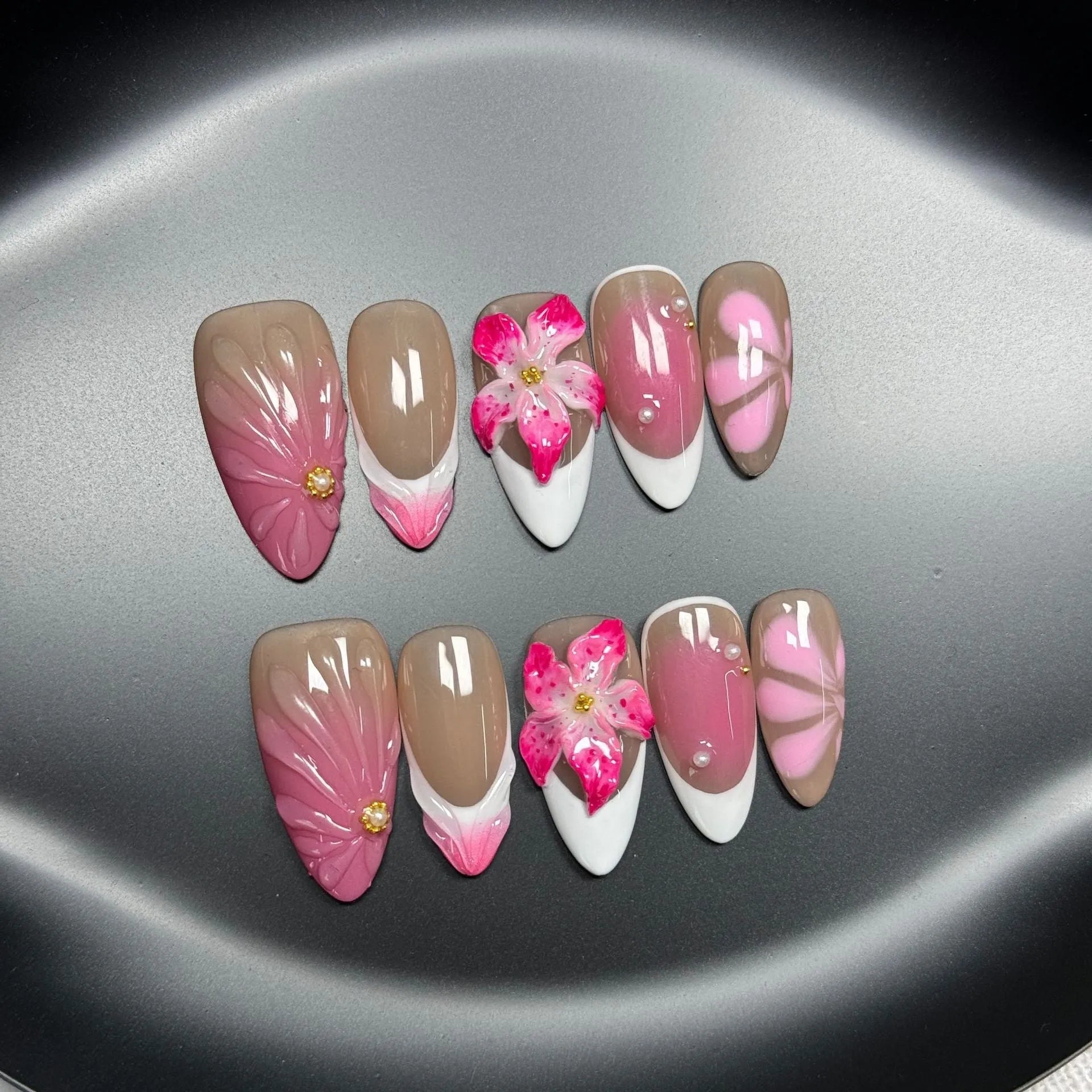 Set of white plastic almond-shaped nail tips with 3D raised lily and ice flower French manicure design.