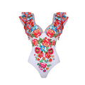 Women's floral printed one-piece polyester swimsuit on a hanger, showing skirted style.